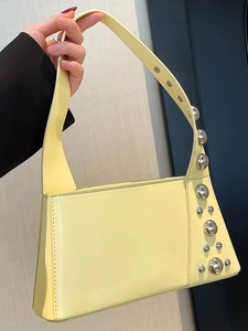 Chic cream leather handbag with silver metallic sphere accents and trapezoid shape