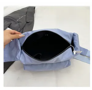 Internal view showing the spacious black lining and zipper of the light blue nylon bag