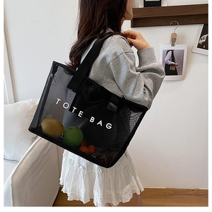 Détail du sac cabas en mesh noir semi-transparent avec larges bretelles et fruits