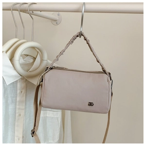 Détail du sac Boston en nylon beige avec poignée nuage plissée et bandoulière tissée