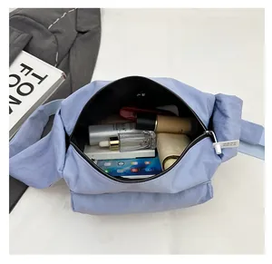 Top view showing spacious interior of light blue nylon crossbody bag with zipper closure