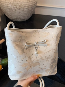Borsa a secchiello bianca con fiocco a farfalla, perle e borchie per donne alla moda