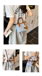 Detail of canvas handbag with brown leather trim and cute wooden rocking horse pendant