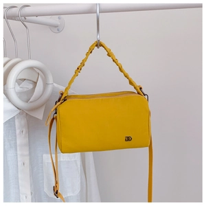 Détail du sac Boston jaune vif avec poignée froncée et logo métallique discret