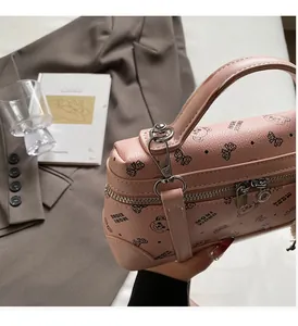Detailed macro view of pink lychee leather handbag featuring cartoon bear and bow prints