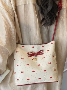 Borsa a tracolla bianca con fiocchi rossi e ciondolo a cuore dorato alla moda