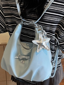 Light blue pleated backpack with bow detail and silver star charm for women