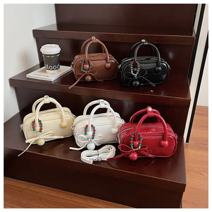 Close-up of stylish mini boston bags in five colors on a wooden display stand