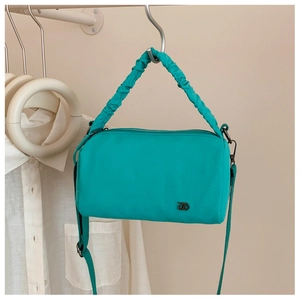 Détail du sac Boston en nylon bleu clair avec poignée froncée et bandoulière réglable