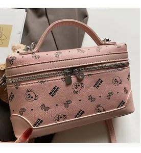 Detail of pink bow-patterned box bag with lychee texture and metallic dual zippers