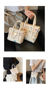 Détail du set de sacs seau en toile imprimée avec motifs graffiti et poignées en cuir
