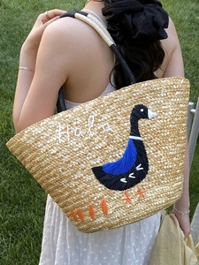 Handwoven straw beach tote with duck embroidery and Hola text for summer vacation