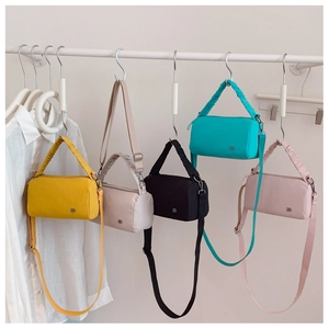 Cinq sacs bandoulière cylindriques en nylon coloré avec poignées plissées sur support
