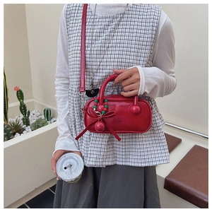 Detailed macro view of glossy red handbag with bow and beaded charm accessories