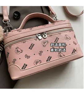 Close-up of pink box-shaped handbag with bear patterns and metal double zippers