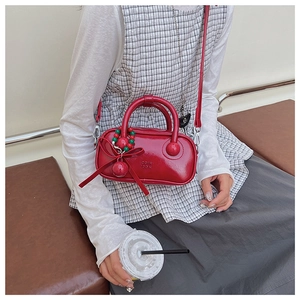 Detail of red patent leather pillow bag with bow and decorative beaded charms