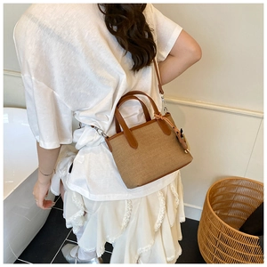 Detail view of retro canvas tote with leather straps worn by a model in a casual setting
