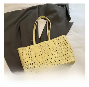 Close-up of laser-cut hollow details on cream yellow tote bag showing craftsmanship
