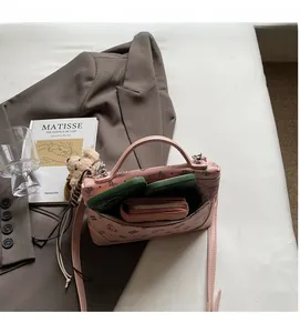 Detail showing the spacious interior of pink floral bear handbag with stored accessories
