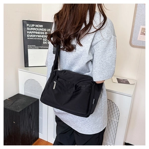 Detail of waterproof black nylon messenger bag featuring durable wide adjustable strap