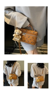 Detail view of caramel crossbody bag with bear patterns and plush bear charm accessory
