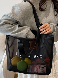 Sac fourre-tout minimaliste en maille noire avec imprimé blanc porté pour un style décontracté