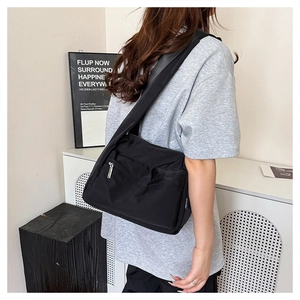 Close-up of a black waterproof nylon crossbody bag with multi-zipper pockets for daily use