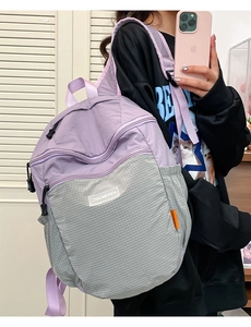 Dettaglio zaino in nylon viola con motivo a griglia grigio e spallacci regolabili