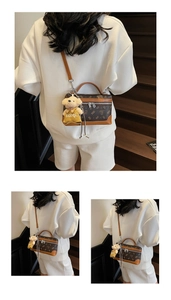 Detailed view of brown monogram handbag with dual zippers and a cute bear plush charm