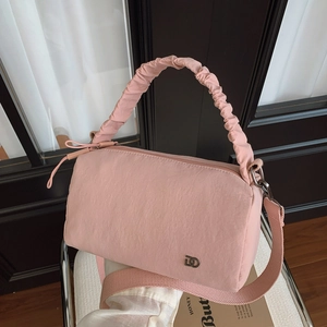 Détail du sac Boston rose avec poignée froncée et bandoulière tissée amovible