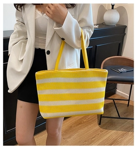 Dettagli della borsa tote intrecciata a righe gialle e bianche con manici sottili