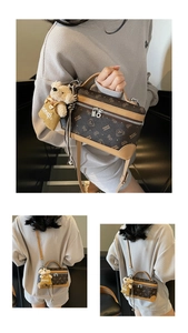 Detail showing the brown monogram cylinder box bag with a cute plush bear charm accessory