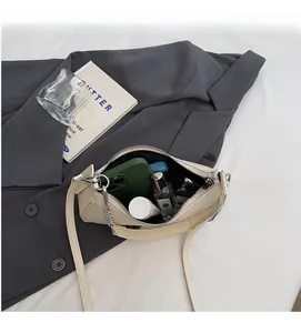 Interior view of cream faux leather baguette bag with silver chain and daily essentials