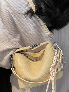 Minimalist light yellow leather tote bag with silver hardware and tennis racket charm