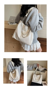 Close-up of cream white glossy leather tote bag with pearl and silver chain details