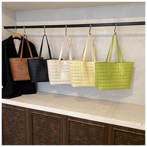 Detailed view of hollowed-out pattern on large capacity tote bags in multiple colors