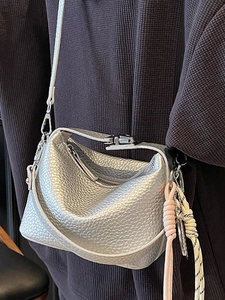 Silver lychee grain leather crescent crossbody bag with woven rope detail on a model