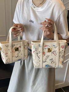 Sac seau élégant en toile blanche avec graffitis colorés et garnitures dorées