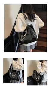 Detail of glossy black tote bag featuring pearl and silver chain decorative elements