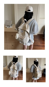 Detail of cream canvas backpack featuring side pockets and a cute plush bear charm accessory