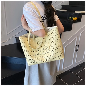 Detail of light yellow hollow-out tote bag with elegant circular perforated patterns