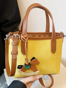 Minimalist yellow canvas tote bag with brown leather trim and a cute wooden horse charm