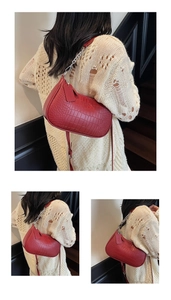 Detail of red crocodile pattern baguette bag with silver chain and chic leather tag