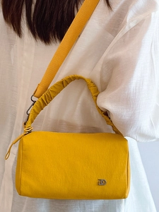 Sac Boston plissé jaune chic avec bandoulière large et pendentif logo métallique