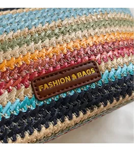 Detail shot of colorful woven texture and brown leather label on the straw bucket bag