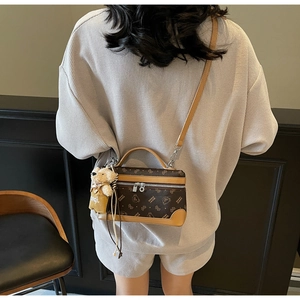 Detailed back view of a mini vintage brown printed handbag with a teddy bear charm