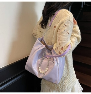 Chic purple glossy tote bag detail with elegant large pearls and silver chain decoration
