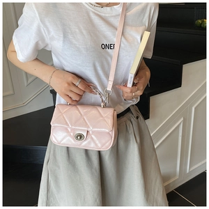 Detail of pink quilted crossbody bag with silver twist lock and chain handle