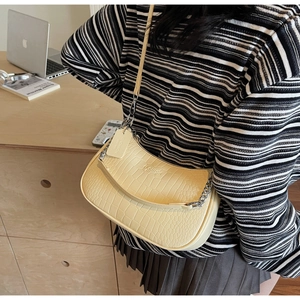 Detail of yellow crocodile embossed hobo bag with silver chain and adjustable leather strap