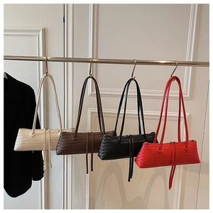 Detail view of woven leather baguette bags in white, brown, black and red colors